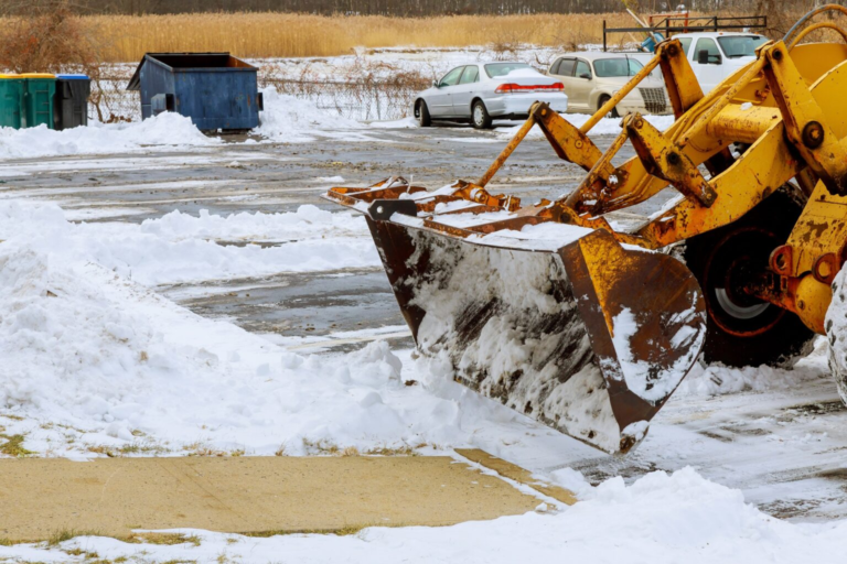 Machinery with snow plough cleaning road removing snow after winter snow storm